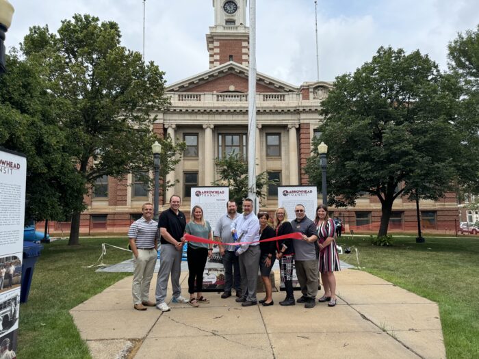 The strong Arrowhead Transit team posses for a picture with the ribbon.